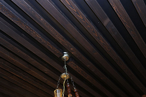 Отделка потолка фальшбалками из хвои для домашнего бара в стиле шале