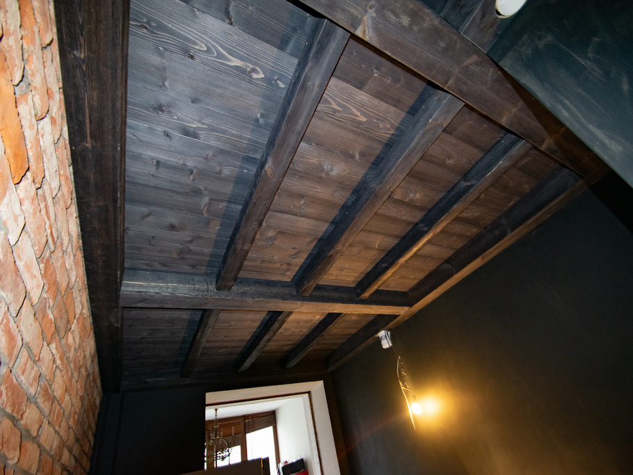 Скрытые провода, зонирование и вековой шарм: почему сосновые фальшбалки — идеальный выбор для кухни в загородном доме