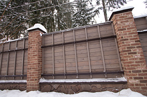 Секционный забор из планкена со столбами отделанными камнем